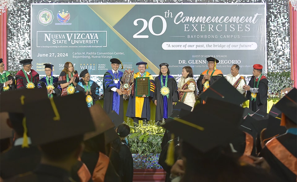Dr. Wilfredo A. Dumale, Jr. (sixth from left), NVSU President, presents to Dr. Glenn Gregorio (sixth from right), SEARCA Center Director, a bolo encased in an ornately carved wooden sheath as a token of appreciation along with a plaque of appreciation for speaking at NVSU’s 20th Commencement Exercises. (Photo credit: NVSU)
